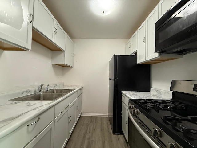 605 Hill Dr Unit 206, Hoffman Estates, IL 60169 - kitchen with stainless steel gas range, black microwave, a sink, wood finished floors, and white cabinets