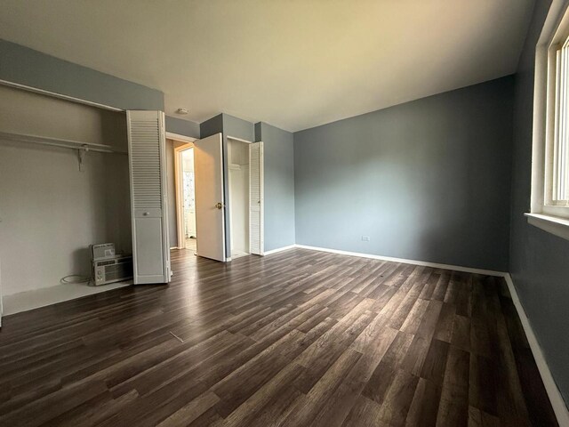 605 Hill Dr Unit 206, Hoffman Estates, IL 60169 - unfurnished bedroom featuring dark wood finished floors, baseboards, and multiple closets