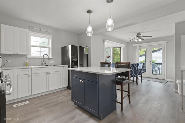 990 Magnolia Ave, Gurnee, IL 60031 - kitchen with a sink, a kitchen bar, white cabinetry, a ceiling fan, and light countertops