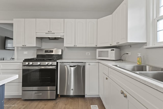 990 Magnolia Ave, Gurnee, IL 60031 - kitchen with stainless steel appliances, under cabinet range hood, white cabinets, and light countertops