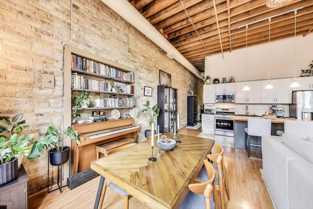 525 N Halsted St Unit 409, Chicago, IL 60642 - dining room with light wood-style floors, a high ceiling, and brick wall
