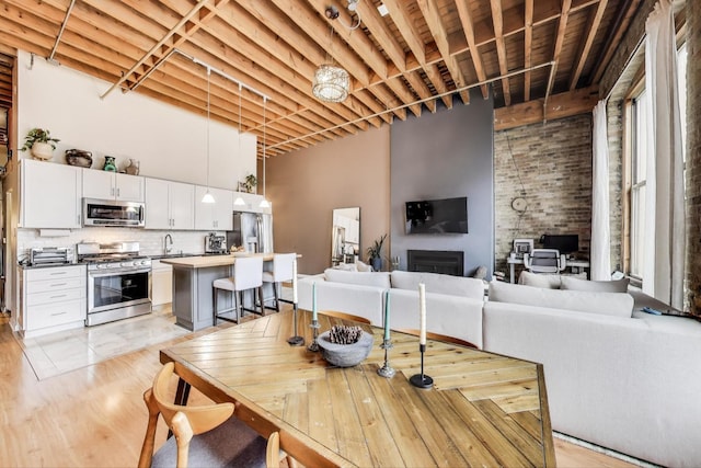 525 N Halsted St Unit 409, Chicago, IL 60642 - dining room with a towering ceiling, a fireplace, and light wood finished floors