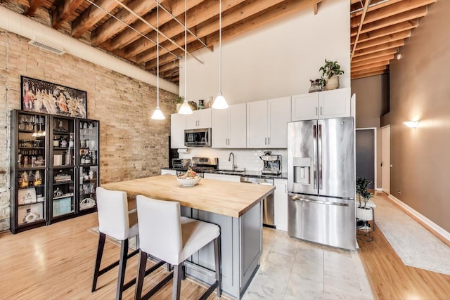 525 N Halsted St Unit 409, Chicago, IL 60642 - kitchen with appliances with stainless steel finishes, a towering ceiling, butcher block counters, a sink, and a center island