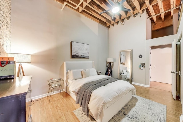 525 N Halsted St Unit 409, Chicago, IL 60642 - bedroom with beamed ceiling, light wood-style flooring, a towering ceiling, and baseboards