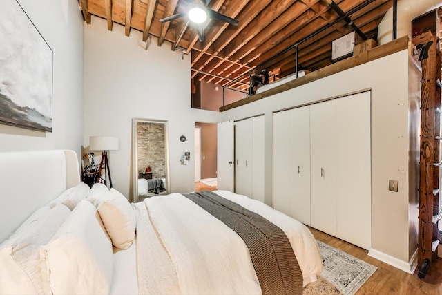 525 N Halsted St Unit 409, Chicago, IL 60642 - bedroom featuring two closets, wood finished floors, baseboards, and a high ceiling