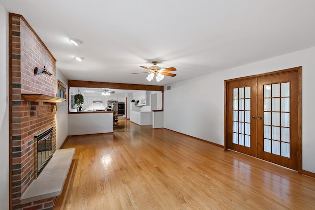 172 Hamilton Ave, Frankfort, IL 60423 - unfurnished living room featuring a brick fireplace, a ceiling fan, wood finished floors, french doors, and baseboards