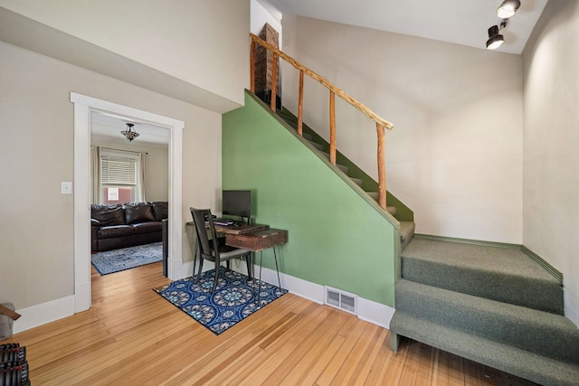 staircase with wood finished floors and baseboards