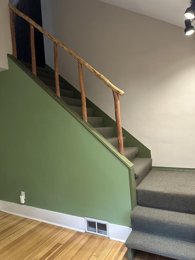staircase with wood finished floors and baseboards