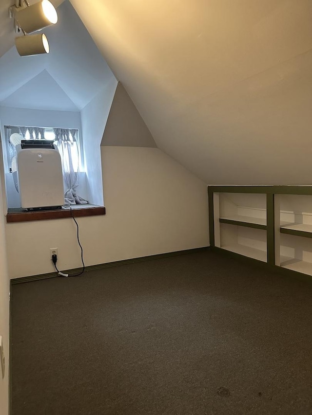 bonus room featuring lofted ceiling and dark carpet