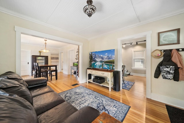 living room featuring light wood-style flooring, baseboards, and ornamental molding