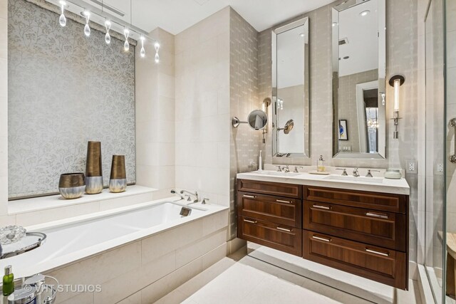 118 E Erie St Unit 21D, Chicago, IL 60611 - bathroom with a garden tub, double vanity, tiled shower, and wallpapered walls