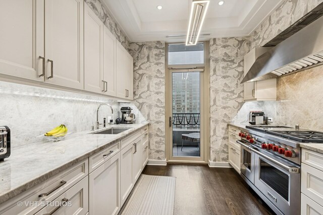 118 E Erie St Unit 21D, Chicago, IL 60611 - kitchen with range with two ovens, a sink, dark wood-style floors, a raised ceiling, and range hood