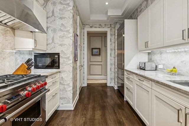 118 E Erie St Unit 21D, Chicago, IL 60611 - kitchen with exhaust hood, high end appliances, wallpapered walls, dark wood finished floors, and white cabinetry