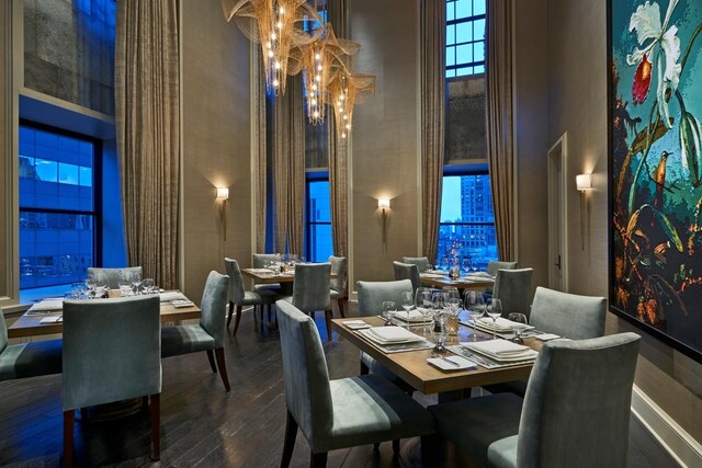 118 E Erie St Unit 21D, Chicago, IL 60611 - dining room featuring a towering ceiling, hardwood / wood-style floors, and a chandelier