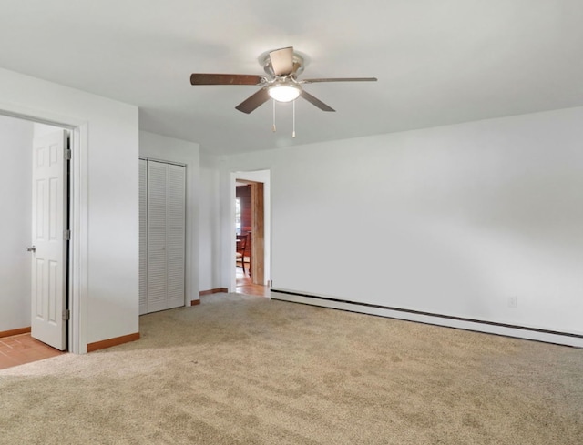 1423 N River Rd, Mchenry, IL 60050 - unfurnished bedroom featuring carpet floors, a baseboard radiator, a closet, a ceiling fan, and baseboards