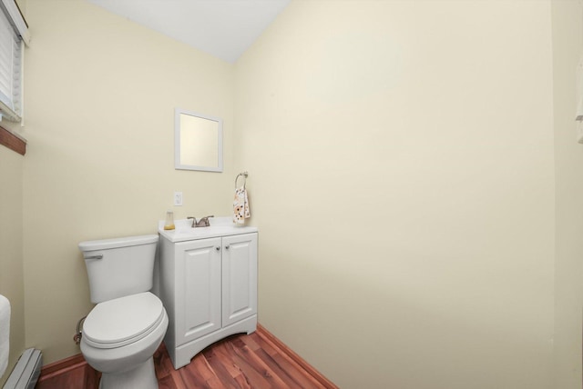 1423 N River Rd, Mchenry, IL 60050 - half bathroom featuring a baseboard radiator, wood finished floors, toilet, and vanity