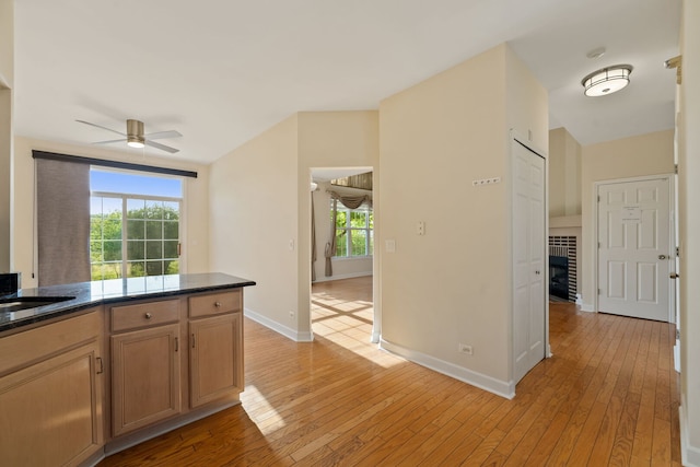 7324 Chestnut Hills Dr, Burr Ridge, IL 60527 - kitchen featuring a ceiling fan, light wood-style flooring, baseboards, and a fireplace