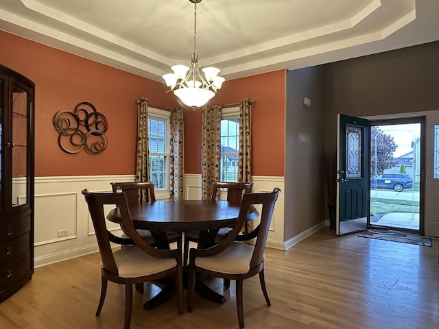 445 Spring Park Loop, Bourbonnais, IL 60914 - dining space with a tray ceiling, wood finished floors, a chandelier, and a wainscoted wall