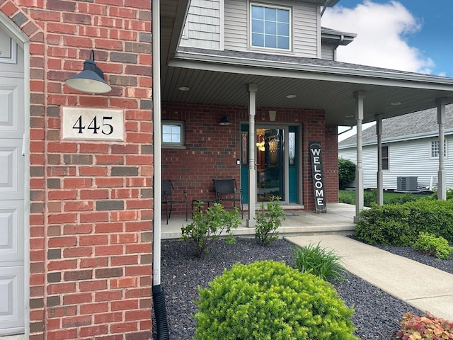 445 Spring Park Loop, Bourbonnais, IL 60914 - entrance to property featuring a porch, brick siding, and central air condition unit