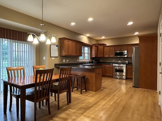 445 Spring Park Loop, Bourbonnais, IL 60914 - kitchen featuring appliances with stainless steel finishes, a peninsula, dark countertops, tasteful backsplash, and a sink