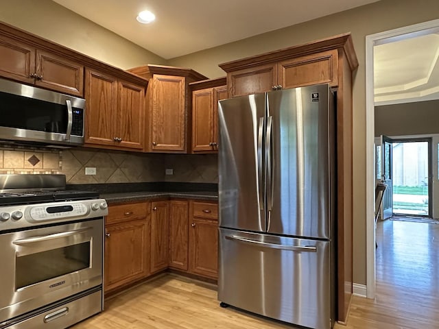 445 Spring Park Loop, Bourbonnais, IL 60914 - kitchen with stainless steel appliances, light wood-style flooring, dark countertops, backsplash, and recessed lighting
