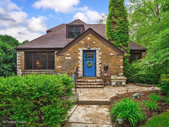 411 Linden Ave, Oak Park, IL 60302 - tudor home with a chimney, a shingled roof, brick siding, and entry steps