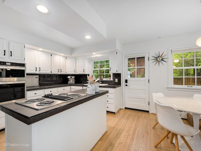 411 Linden Ave, Oak Park, IL 60302 - kitchen featuring stovetop with downdraft, dark countertops, white cabinetry, tasteful backsplash, and recessed lighting