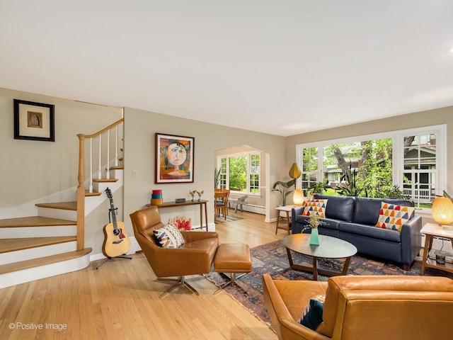 411 Linden Ave, Oak Park, IL 60302 - living room featuring light wood-style flooring, a baseboard heating unit, baseboards, stairs, and arched walkways