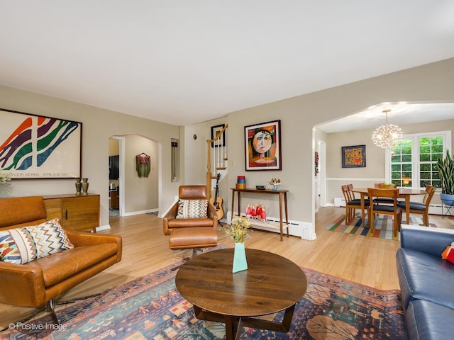 411 Linden Ave, Oak Park, IL 60302 - living room featuring arched walkways, a chandelier, wood finished floors, baseboard heating, and baseboards