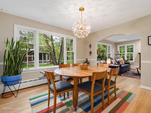 411 Linden Ave, Oak Park, IL 60302 - dining room featuring light wood-style floors, baseboard heating, arched walkways, and a chandelier