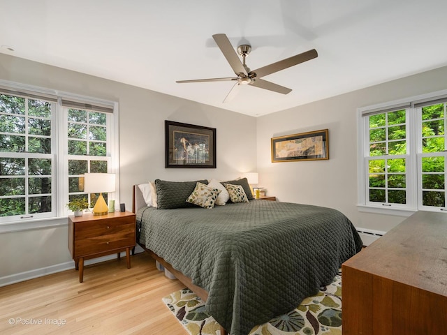 411 Linden Ave, Oak Park, IL 60302 - bedroom with baseboard heating, light wood finished floors, multiple windows, and baseboards