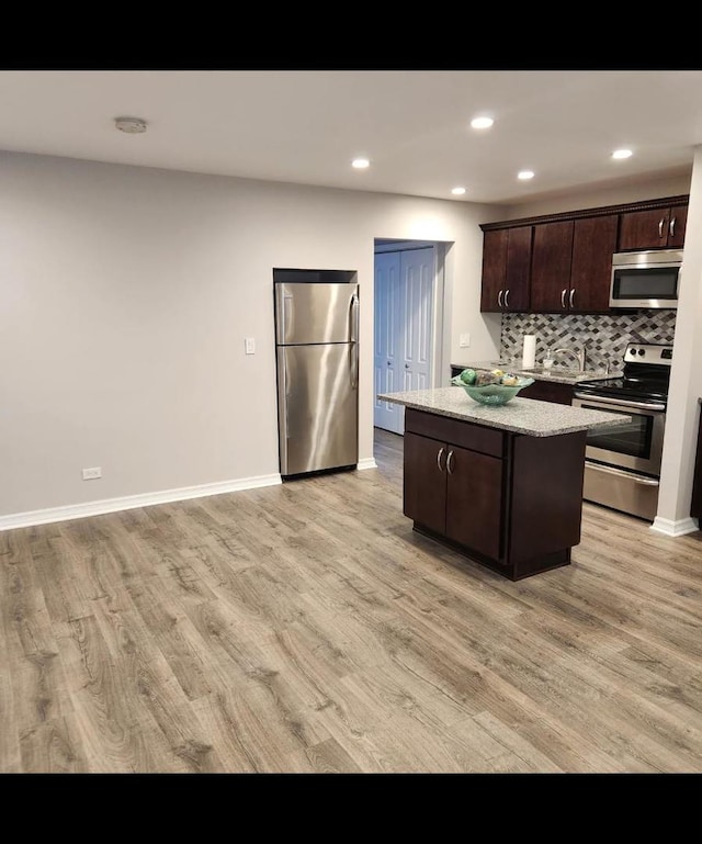 720 N Western Ave Unit 10, Park Ridge, IL 60068 - kitchen with stainless steel appliances, a kitchen island, light wood finished floors, dark brown cabinets, and recessed lighting