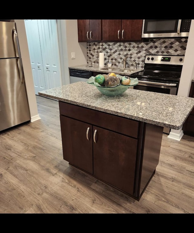 720 N Western Ave Unit 10, Park Ridge, IL 60068 - kitchen with appliances with stainless steel finishes, a sink, light wood-style flooring, tasteful backsplash, and light stone countertops
