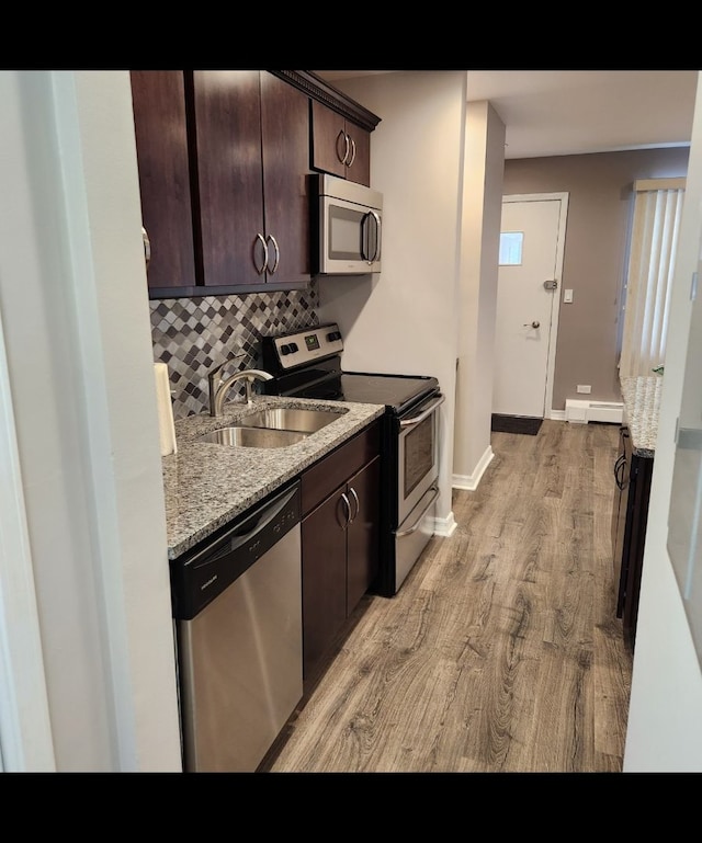 720 N Western Ave Unit 10, Park Ridge, IL 60068 - kitchen featuring appliances with stainless steel finishes, a sink, light wood finished floors, dark brown cabinetry, and decorative backsplash