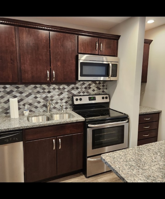 720 N Western Ave Unit 10, Park Ridge, IL 60068 - kitchen with appliances with stainless steel finishes, a sink, dark brown cabinets, decorative backsplash, and light stone counters