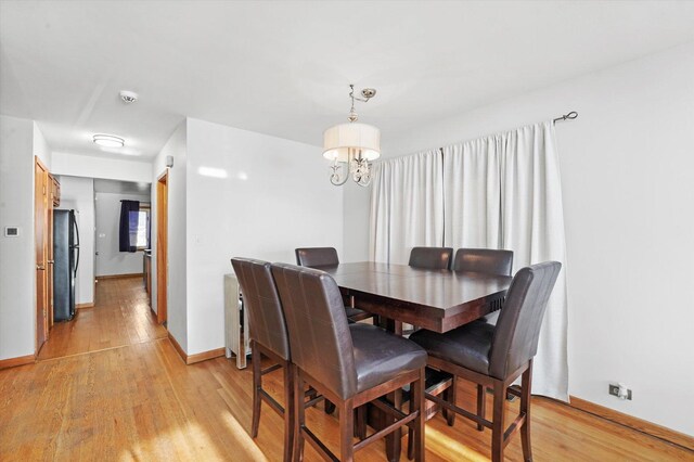 3405 N Osage Ave, Chicago, IL 60634 - dining area with light wood finished floors, baseboards, and a chandelier