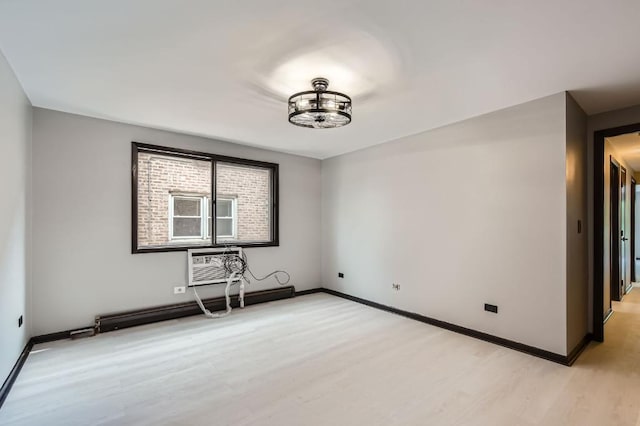 3843 N Narragansett Ave Unit 201, Chicago, IL 60634 - empty room featuring light wood-style flooring, baseboards, baseboard heating, a wall mounted air conditioner, and a chandelier