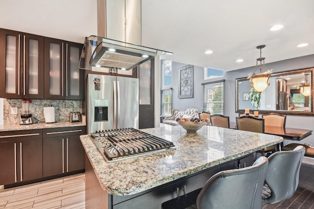 1 Churchill Ct, South Elgin, IL 60177 - kitchen featuring stainless steel fridge with ice dispenser, wood tiled floors, light stone countertops, hanging light fixtures, and decorative backsplash