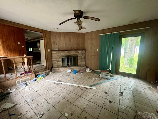 103 W 2nd St, Broadlands, IL 61816 - unfurnished living room featuring wooden walls, ceiling fan, and a stone fireplace