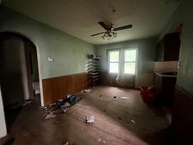 103 W 2nd St, Broadlands, IL 61816 - unfurnished dining area featuring wainscoting, ceiling fan, arched walkways, and wooden walls