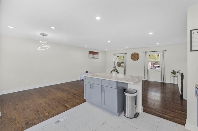 1810 Portsmouth Ln, Schaumburg, IL 60194 - kitchen featuring gray cabinetry, recessed lighting, light wood-style flooring, light stone countertops, and pendant lighting
