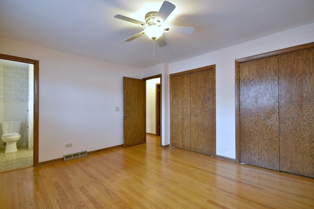 4732 N Anthon Ave, Chicago, IL 60656 - unfurnished bedroom featuring two closets, light wood finished floors, ensuite bathroom, ceiling fan, and baseboards