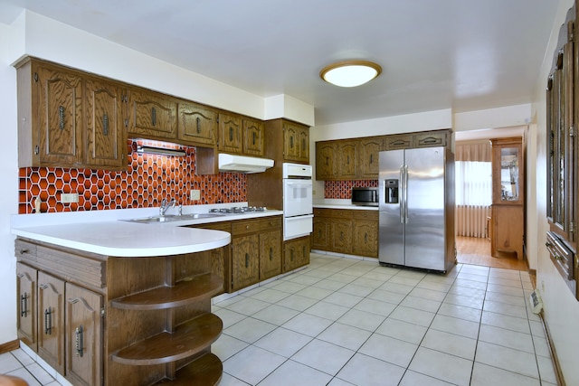 4732 N Anthon Ave, Chicago, IL 60656 - kitchen with appliances with stainless steel finishes, a warming drawer, a sink, a peninsula, and tasteful backsplash