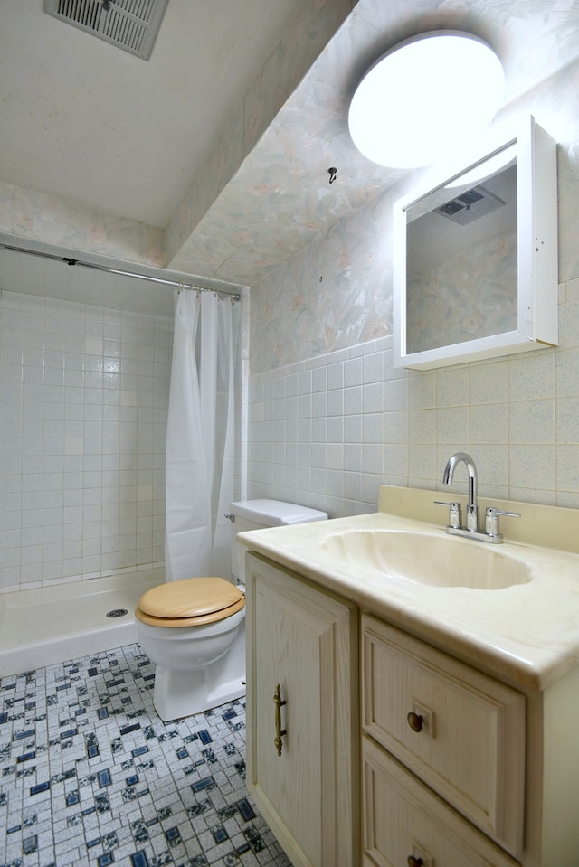 4732 N Anthon Ave, Chicago, IL 60656 - bathroom with vanity, toilet, tile walls, a tile shower, and tile patterned floors
