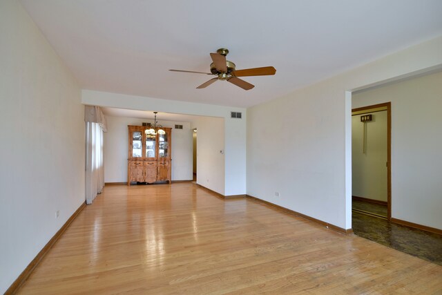 4732 N Anthon Ave, Chicago, IL 60656 - unfurnished living room featuring a chandelier, light wood-type flooring, a ceiling fan, and baseboards