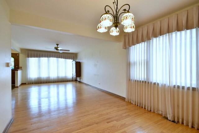 4732 N Anthon Ave, Chicago, IL 60656 - empty room featuring light wood-style flooring, a chandelier, a ceiling fan, and baseboards