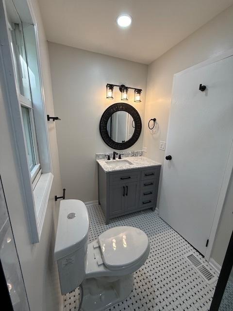 2030 University Dr, Naperville, IL 60565 - bathroom with toilet, vanity, tile patterned floors, and baseboards