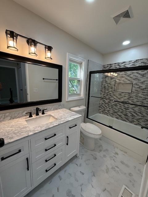 2030 University Dr, Naperville, IL 60565 - full bath featuring vanity, toilet, shower / bath combination with glass door, marble finish floors, and recessed lighting