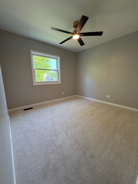 2030 University Dr, Naperville, IL 60565 - spare room featuring a ceiling fan, baseboards, and light carpet