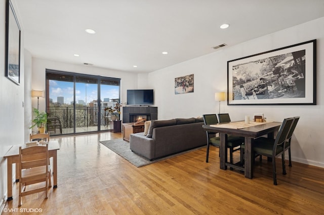 1618 S Halsted St Unit 4D, Chicago, IL 60608 - living room with light wood-style floors, recessed lighting, a tiled fireplace, and baseboards